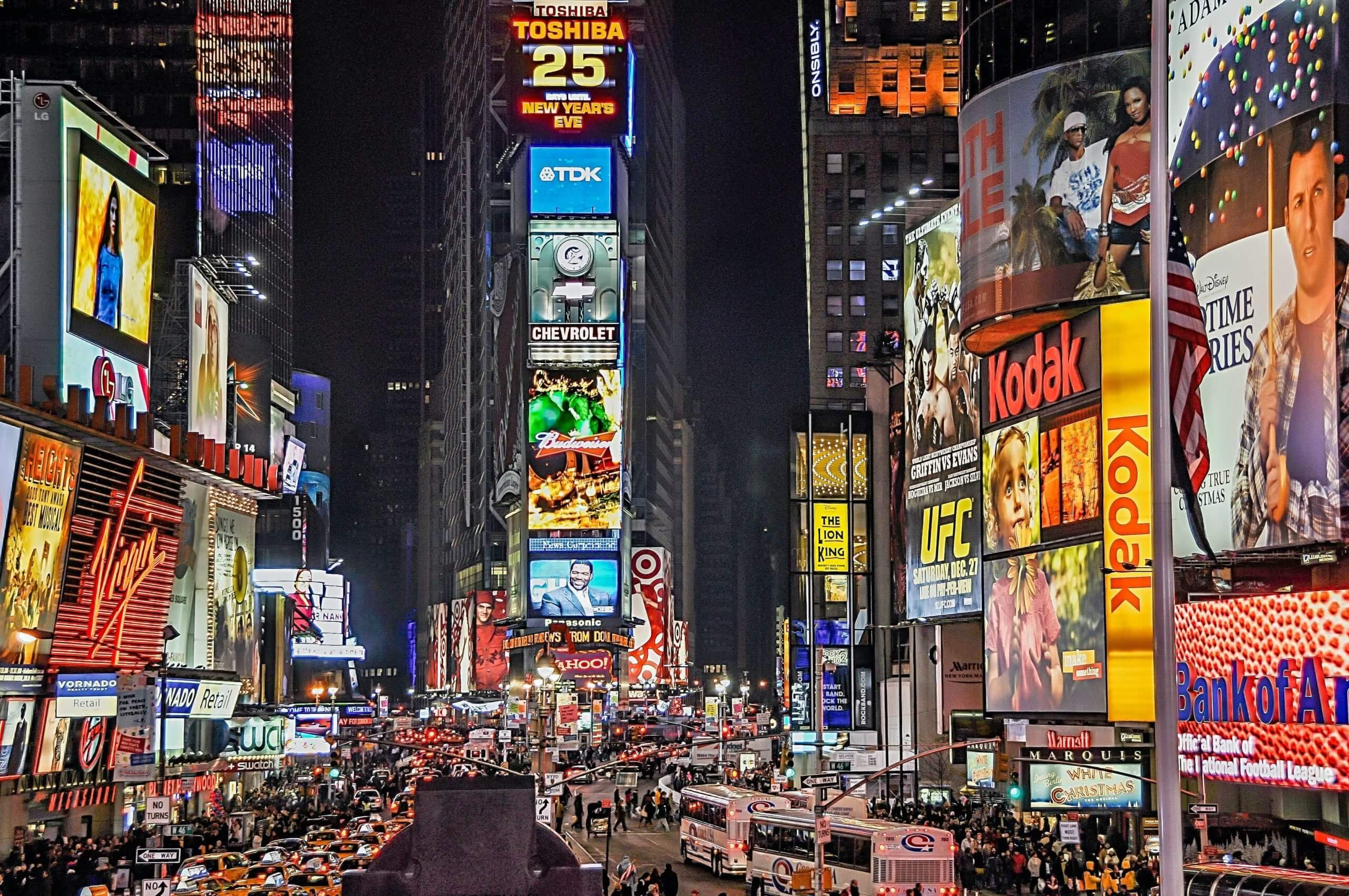 Neon signs and billboards illuminate the busy streets in New York’s Times Square at night.